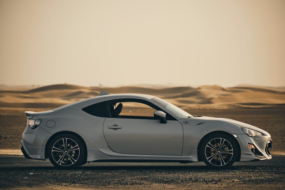 A silver sports car on a desert road